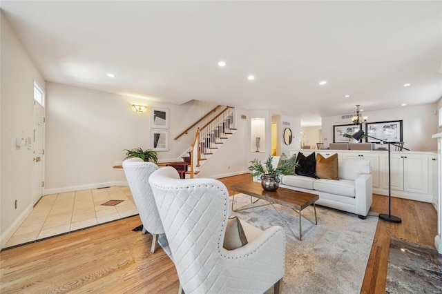 living room featuring stairs, light wood-style flooring, recessed lighting, and a chandelier