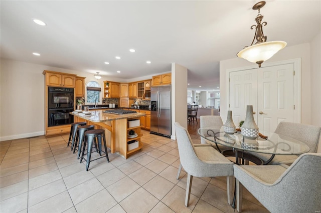 kitchen featuring a sink, a breakfast bar area, appliances with stainless steel finishes, light tile patterned flooring, and open shelves