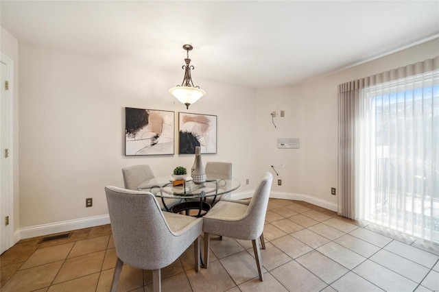 dining room with light tile patterned floors, visible vents, and plenty of natural light