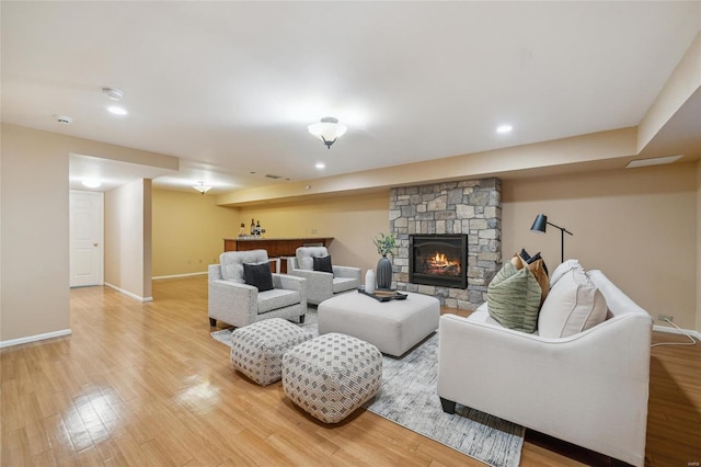 living area featuring recessed lighting, light wood-type flooring, baseboards, and a fireplace