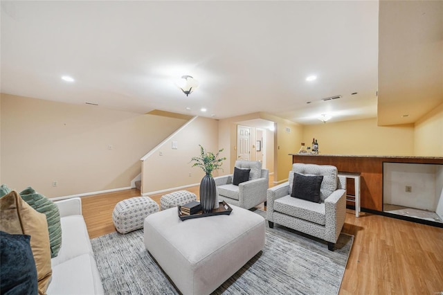 living area featuring visible vents, light wood-style flooring, recessed lighting, stairway, and baseboards