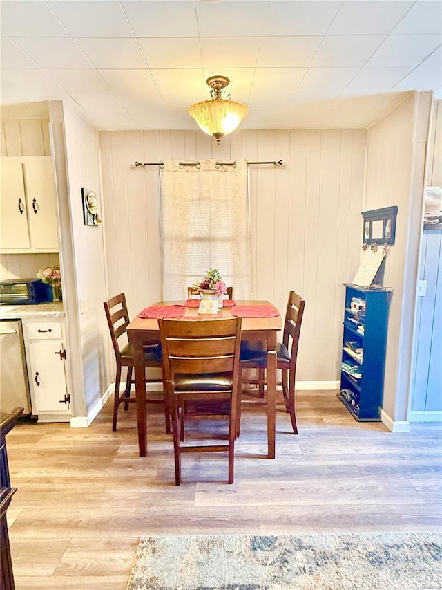 dining room featuring light wood-style flooring and baseboards