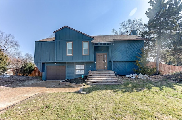 view of front of home featuring board and batten siding, fence, a front yard, a garage, and driveway