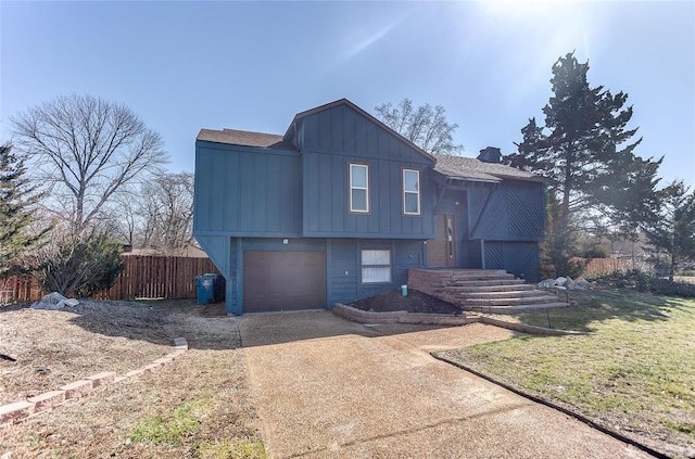 view of front facade with a garage, board and batten siding, concrete driveway, and fence