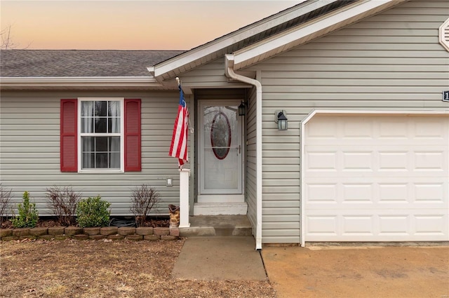 exterior entry at dusk featuring a garage