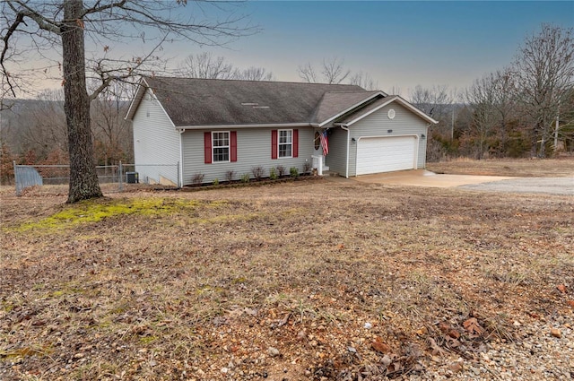 ranch-style home with a garage, central AC unit, and a front yard