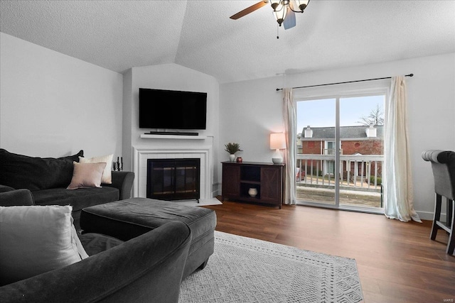 living room with a textured ceiling, wood-type flooring, ceiling fan, and vaulted ceiling