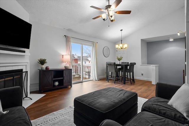 living room featuring vaulted ceiling, hardwood / wood-style floors, a textured ceiling, and a fireplace