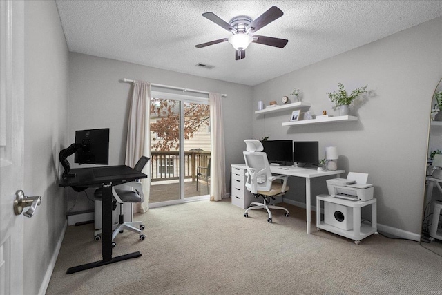 carpeted home office with ceiling fan and a textured ceiling