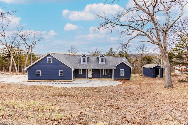 cape cod-style house featuring a storage shed