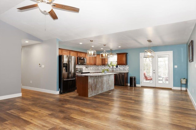 kitchen featuring decorative light fixtures, a center island, decorative backsplash, and appliances with stainless steel finishes