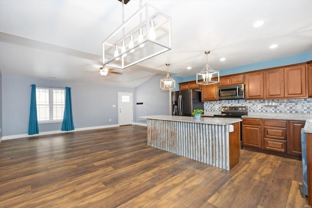 kitchen featuring appliances with stainless steel finishes, pendant lighting, dark hardwood / wood-style flooring, decorative backsplash, and a center island