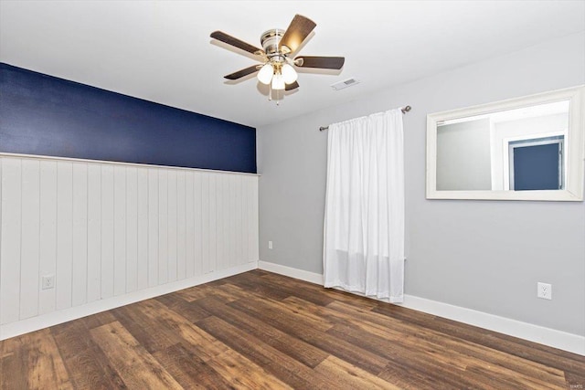 empty room with dark wood-type flooring and ceiling fan