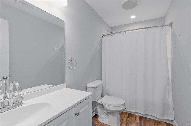 bathroom featuring vanity, hardwood / wood-style floors, curtained shower, and toilet