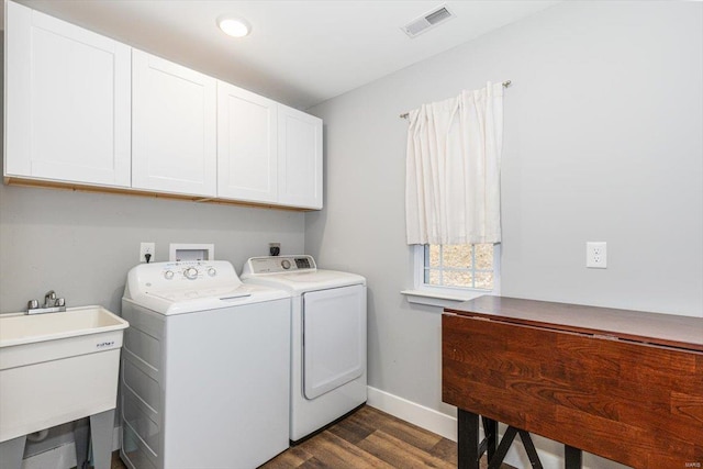 washroom featuring cabinets, washing machine and dryer, sink, and dark wood-type flooring