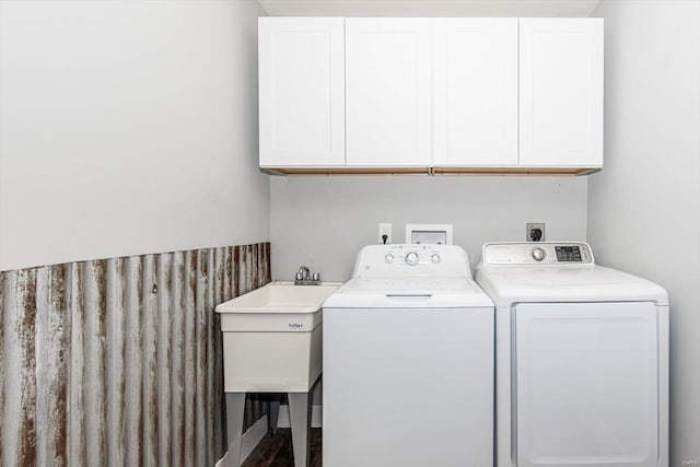 clothes washing area with cabinets, separate washer and dryer, and sink