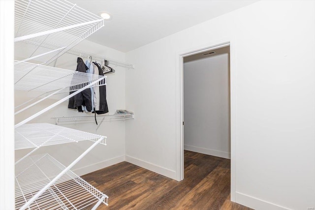 walk in closet with dark hardwood / wood-style flooring