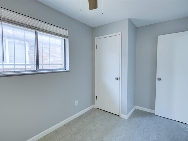 unfurnished bedroom with ceiling fan and light wood-type flooring