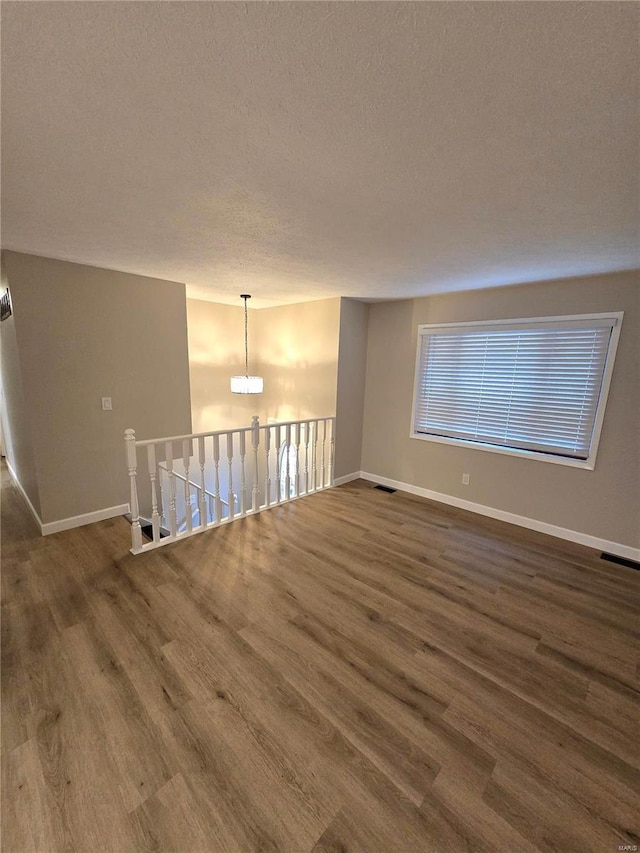 empty room featuring dark hardwood / wood-style floors and a textured ceiling