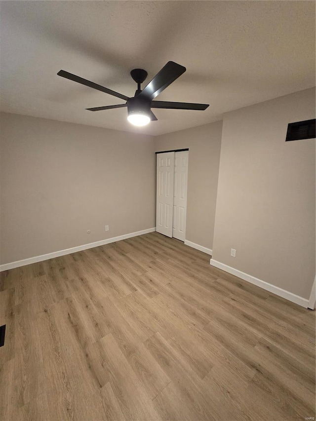 unfurnished bedroom with ceiling fan, a textured ceiling, a closet, and light wood-type flooring