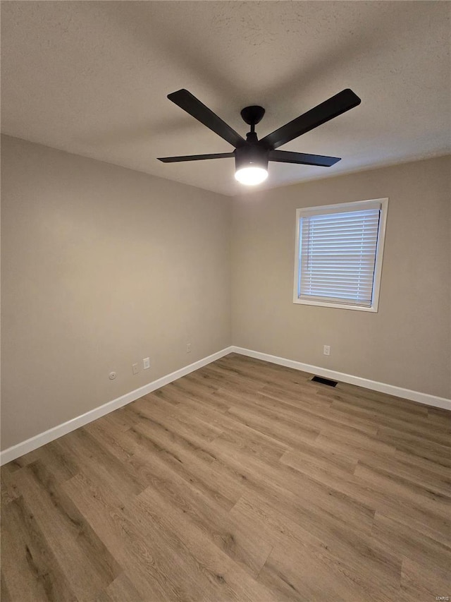 unfurnished room with ceiling fan, a textured ceiling, and light hardwood / wood-style flooring