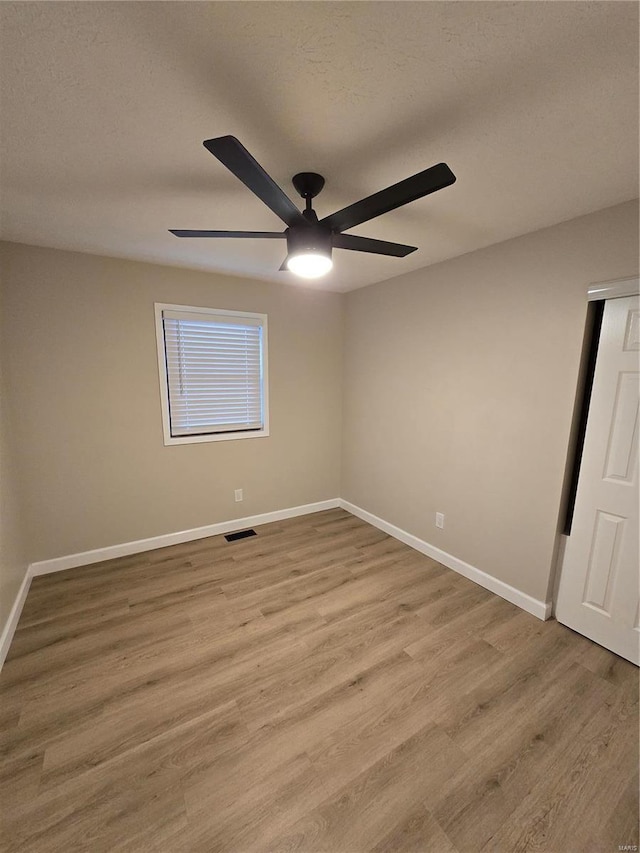 unfurnished room featuring ceiling fan, a textured ceiling, and light wood-type flooring