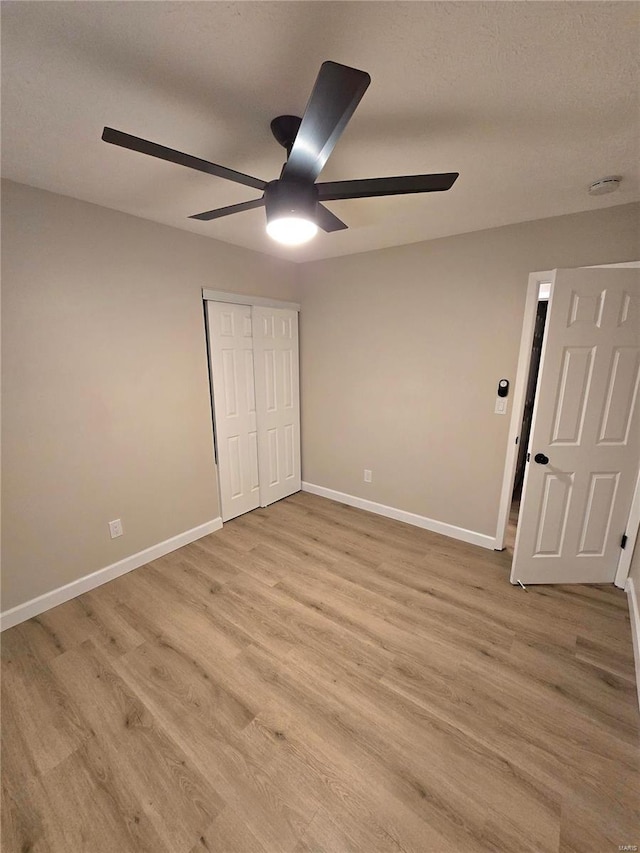 unfurnished bedroom with ceiling fan, light hardwood / wood-style floors, and a closet