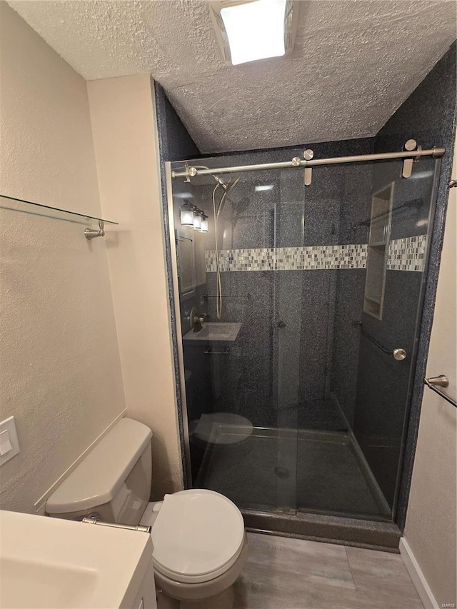 bathroom with an enclosed shower, sink, a textured ceiling, and toilet