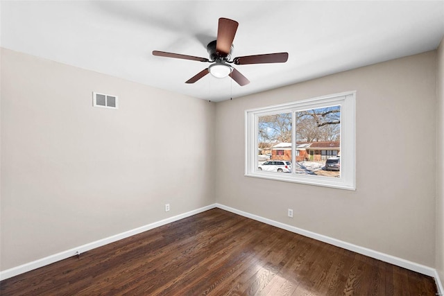 empty room with a ceiling fan, visible vents, baseboards, and dark wood-type flooring