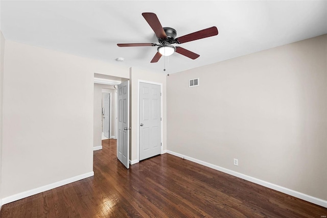 unfurnished bedroom with dark wood-style floors, baseboards, visible vents, and a ceiling fan