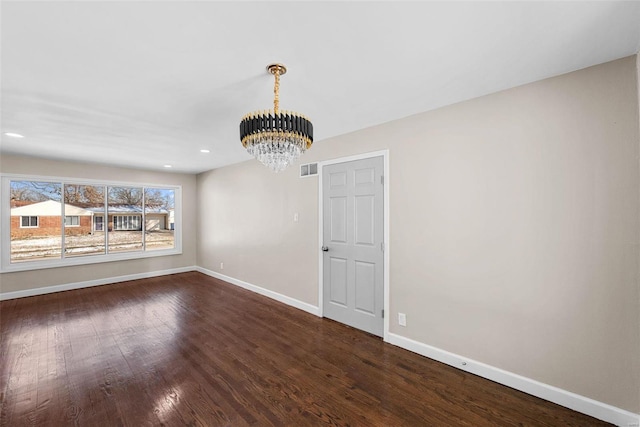 unfurnished dining area featuring dark wood finished floors, recessed lighting, visible vents, an inviting chandelier, and baseboards