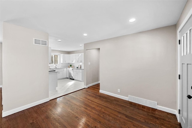 unfurnished living room with light wood-style flooring, visible vents, baseboards, and recessed lighting