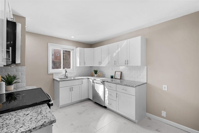 kitchen with marble finish floor, stainless steel dishwasher, white cabinets, a sink, and baseboards