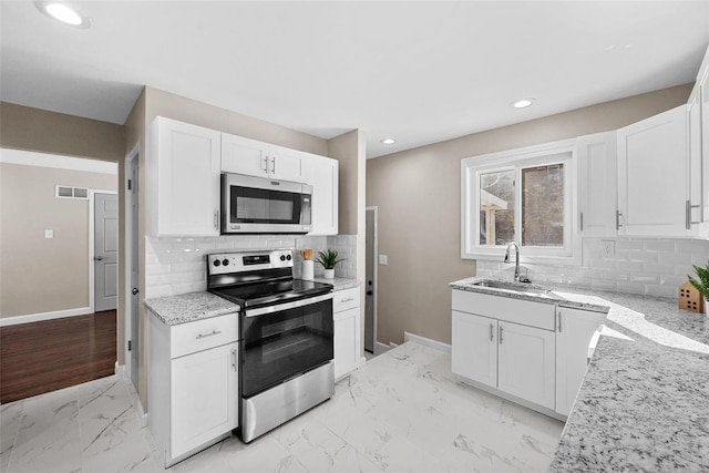 kitchen with marble finish floor, visible vents, appliances with stainless steel finishes, white cabinets, and a sink