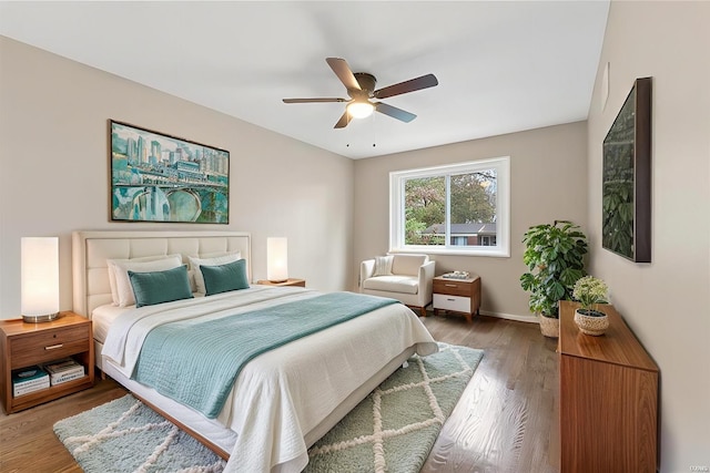 bedroom with ceiling fan, baseboards, and wood finished floors