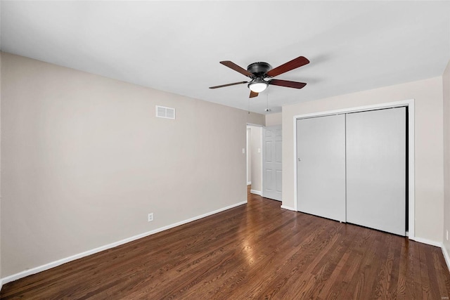 unfurnished bedroom with wood finished floors, a ceiling fan, visible vents, baseboards, and a closet