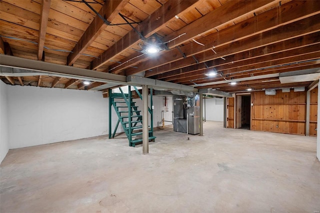 unfinished basement with heating unit and stairway