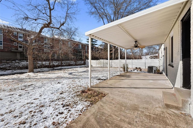 snowy yard with a ceiling fan, fence, a patio, and central air condition unit