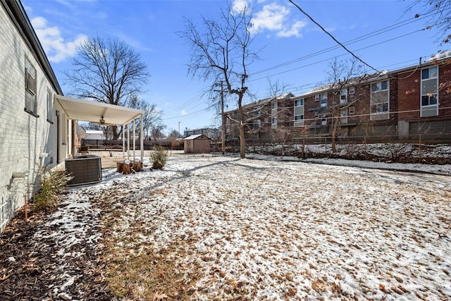 yard covered in snow featuring a residential view, fence, and cooling unit