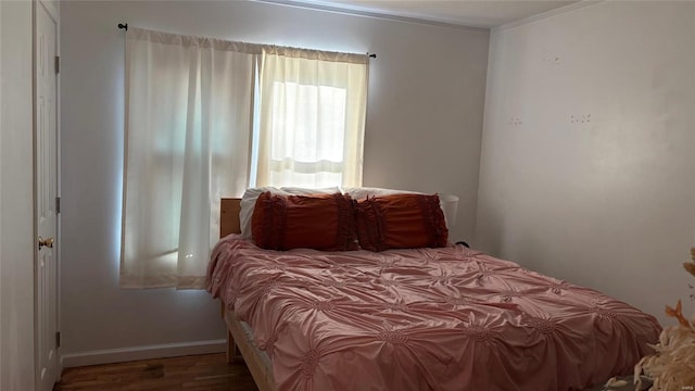 bedroom with hardwood / wood-style floors and crown molding