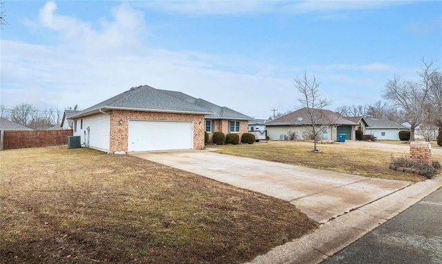 ranch-style home featuring cooling unit, a garage, and a front yard