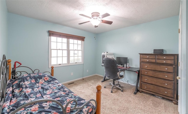 carpeted bedroom featuring ceiling fan and a textured ceiling