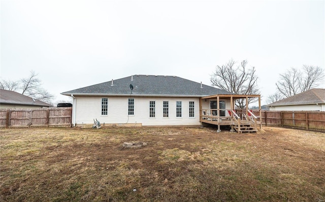 rear view of house with a lawn and a deck