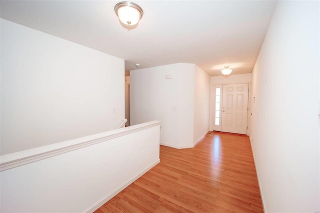 corridor featuring light wood-style floors and baseboards