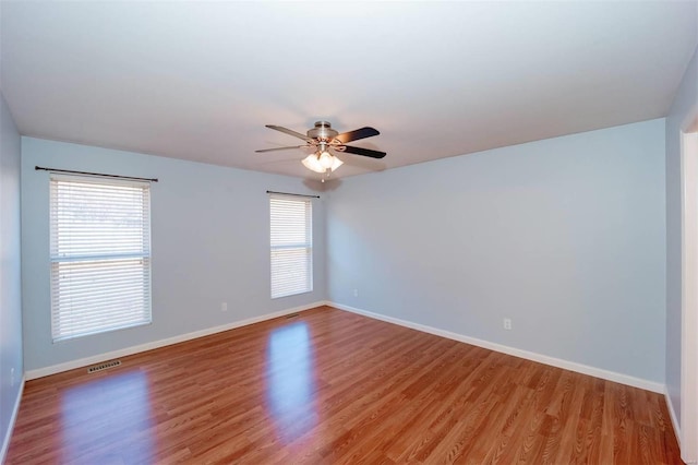 unfurnished room featuring a ceiling fan, visible vents, light wood finished floors, and baseboards