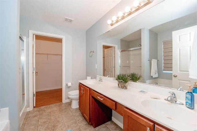 bathroom featuring tile patterned flooring, a sink, visible vents, and a shower stall