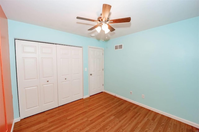 unfurnished bedroom featuring light wood-style floors, a closet, visible vents, and baseboards