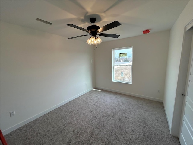 carpeted spare room featuring ceiling fan