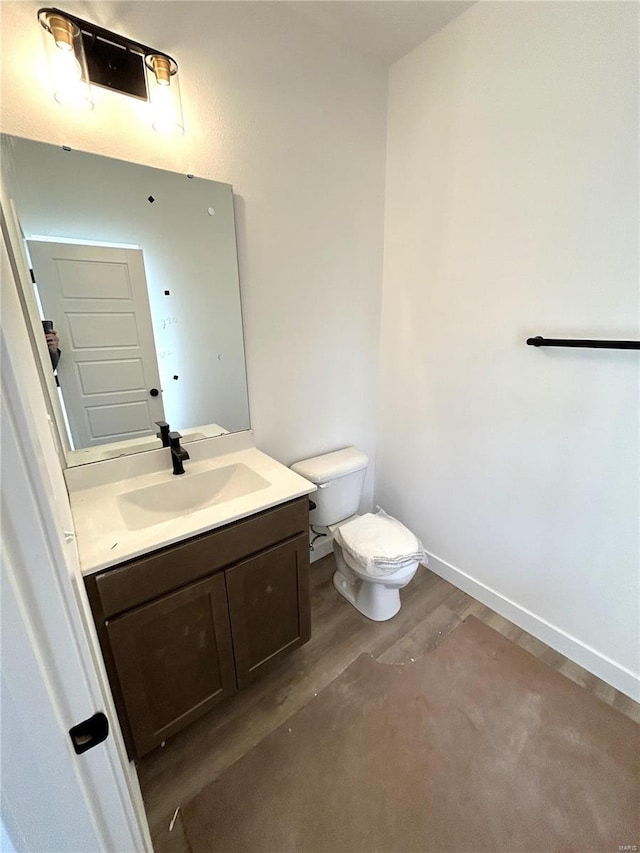 bathroom featuring vanity, wood-type flooring, and toilet