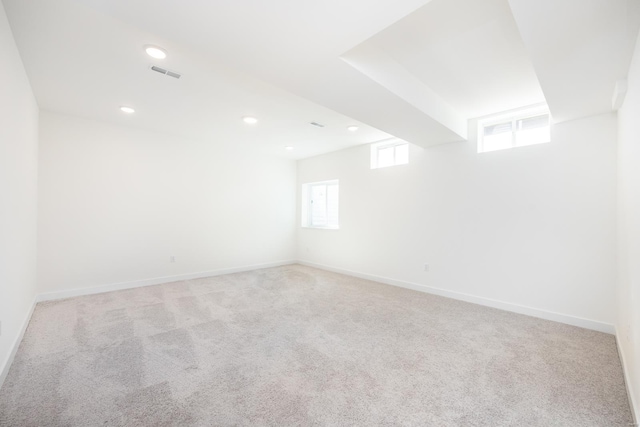 unfurnished room with a wealth of natural light, visible vents, baseboards, and carpet